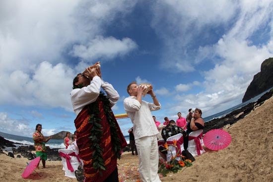 wedding photo blowing conch shell